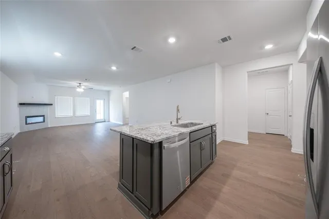 a kitchen with stainless steel appliances granite countertop a stove a sink and a refrigerator