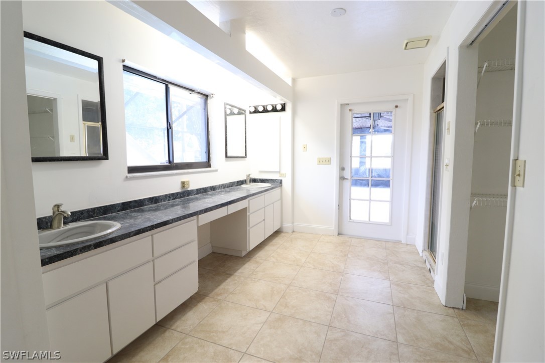 2102 Hibiscus Road Fort Myers, FL 33905 - Photo 12 of 23 a spacious bathroom with a granite countertop sink a mirror and a