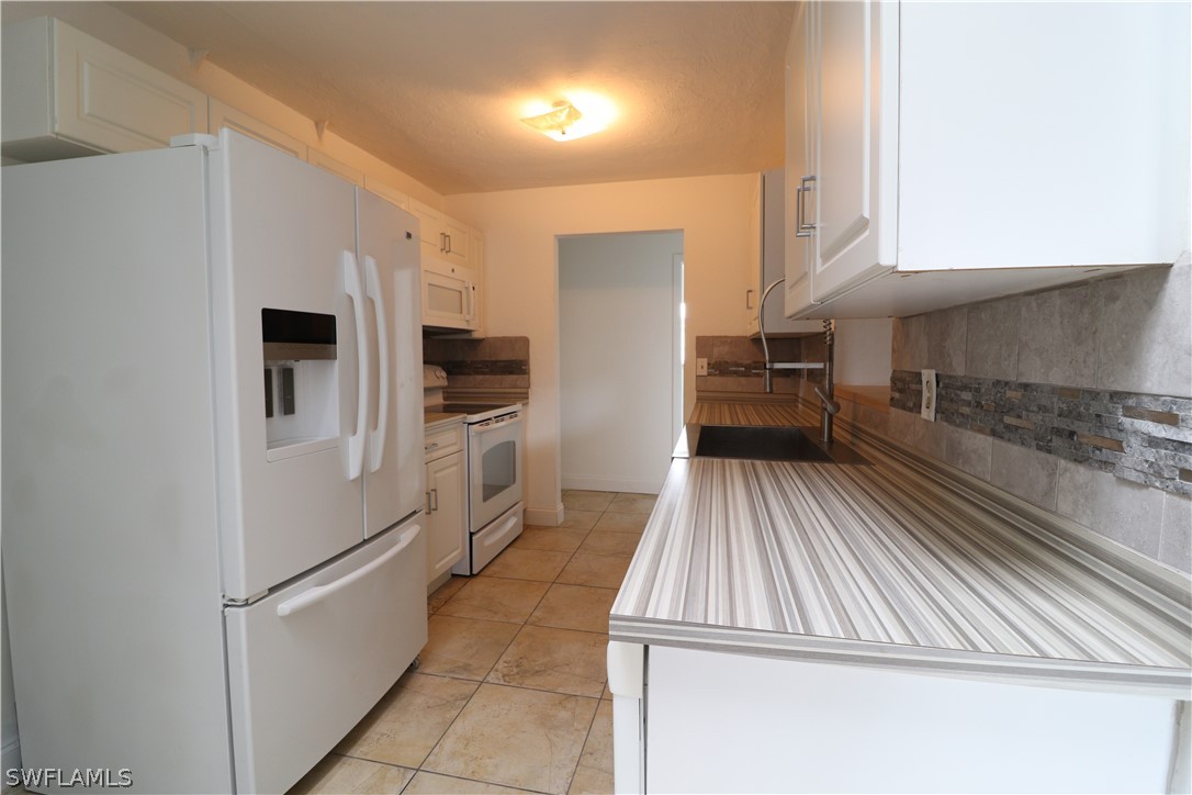 2102 Hibiscus Road Fort Myers, FL 33905 - Photo 5 of 23 a kitchen with a refrigerator and a sink