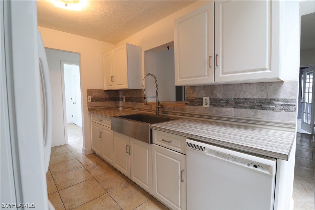 2102 Hibiscus Road Fort Myers, FL 33905 - Photo 6 of 23 a kitchen with granite countertop white cabinets and sink