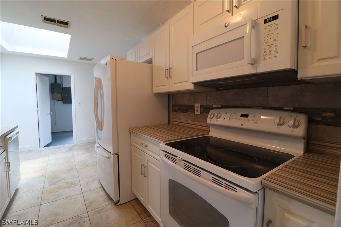 2102 Hibiscus Road Fort Myers, FL 33905 - Photo 7 of 23 a kitchen with granite countertop white cabinets and white appliances