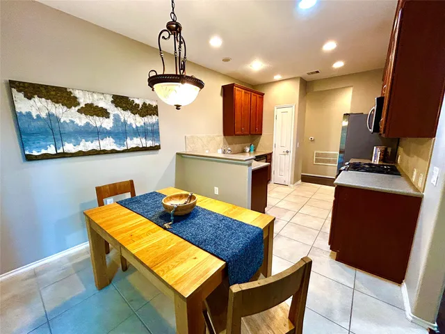 a kitchen with stainless steel appliances kitchen island granite countertop a table chairs in it and wooden floors