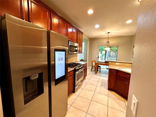 a kitchen with stainless steel appliances granite countertop a refrigerator and a stove