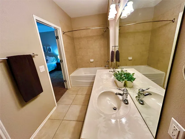 a bathroom with a tub sink and mirror