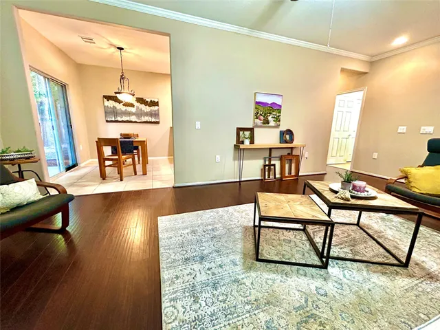 a living room with furniture and a wooden floor