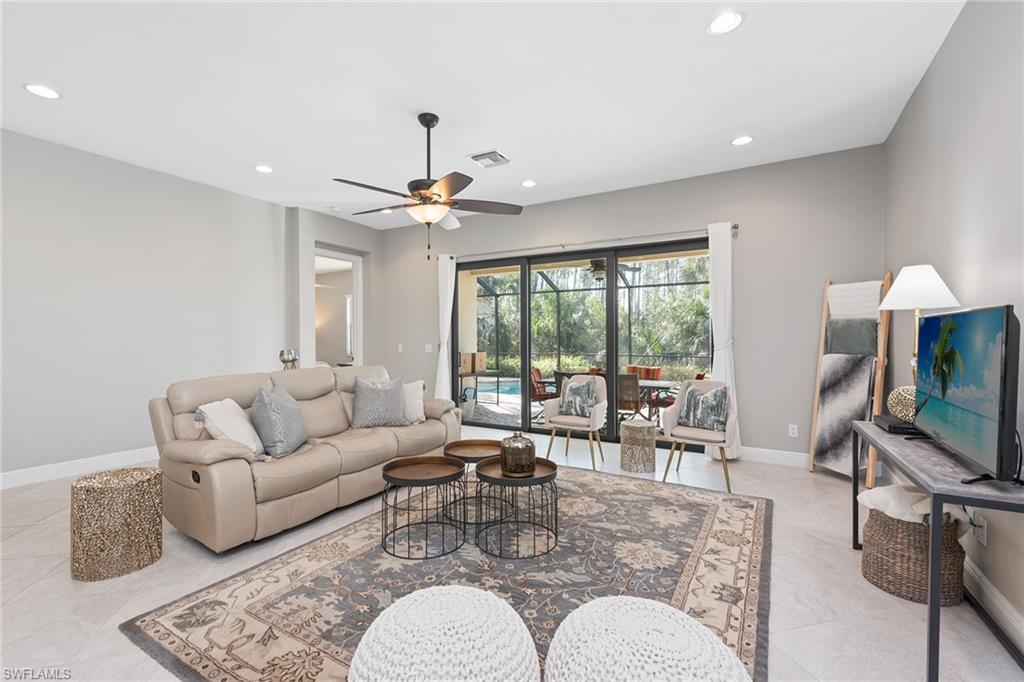 a living room with furniture a flat screen tv and a large window