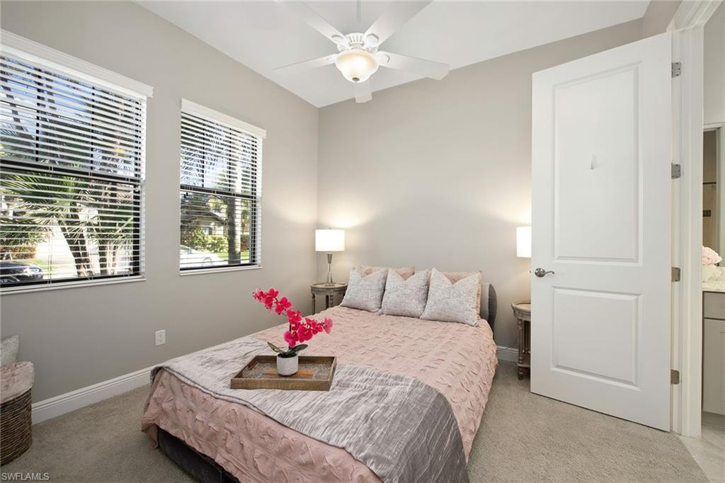 4359 Raffia Palm Circle Naples, FL 34119 - Photo 12 of 35 a bedroom with a bed and a chandelier