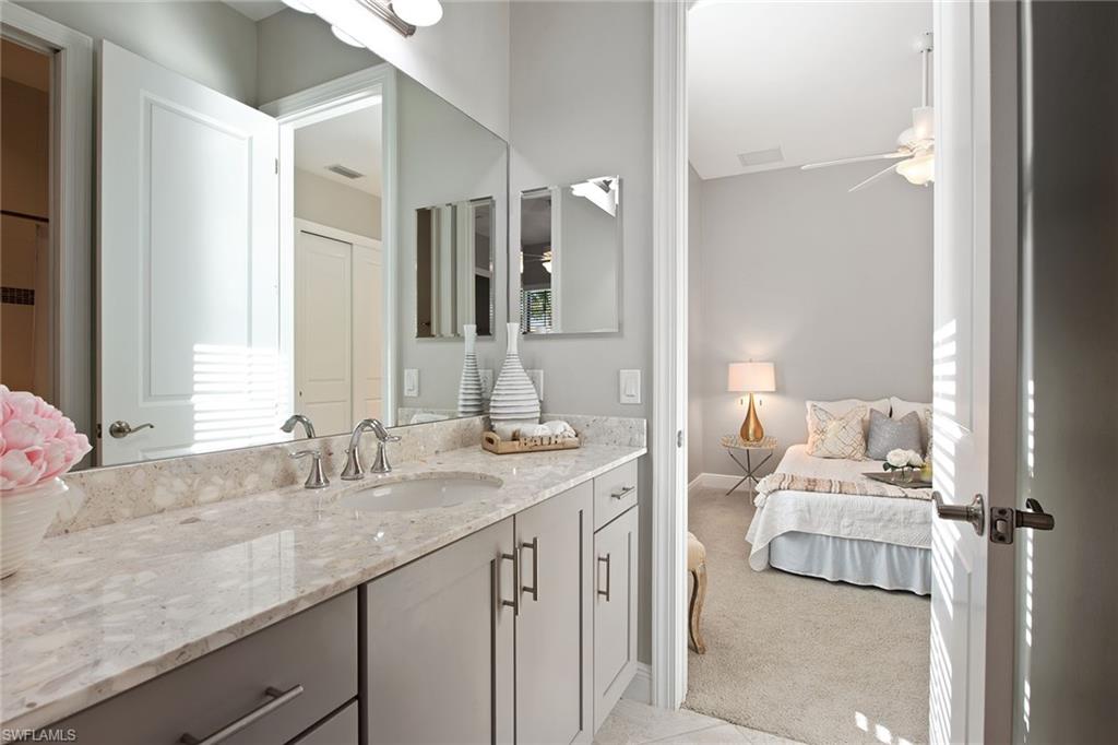 4359 Raffia Palm Circle Naples, FL 34119 - Photo 13 of 35 a en suite bathroom with a granite countertop sink and a mirror