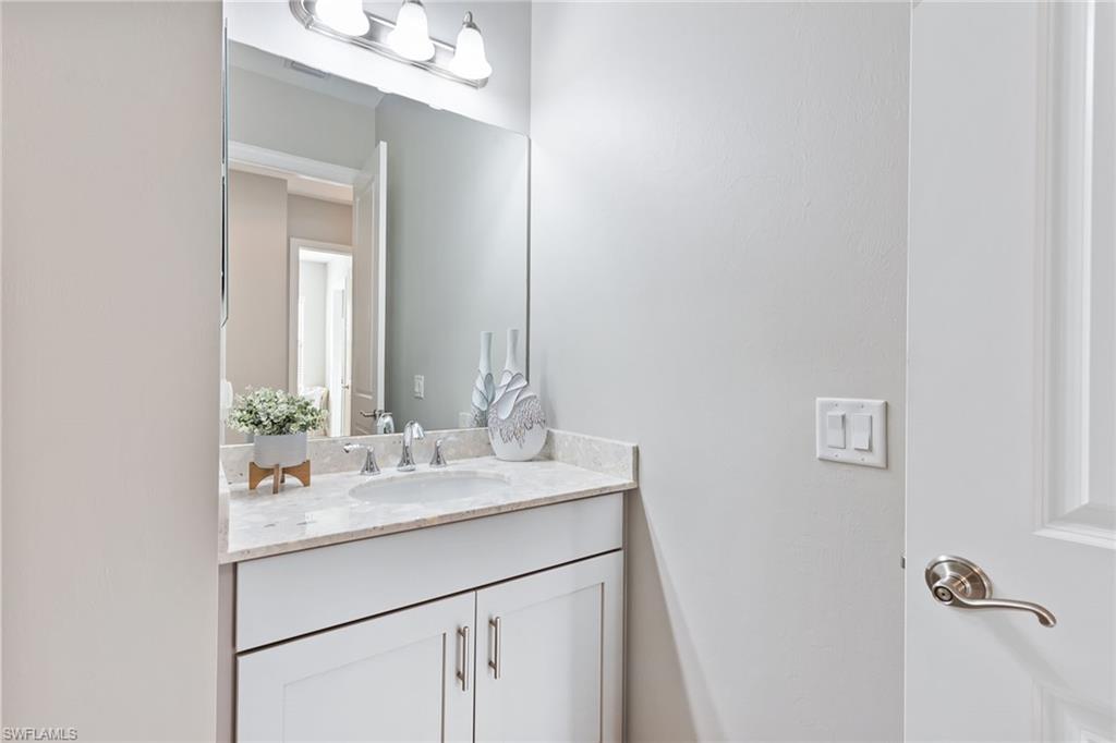4359 Raffia Palm Circle Naples, FL 34119 - Photo 18 of 35 a bathroom with a sink and a mirror
