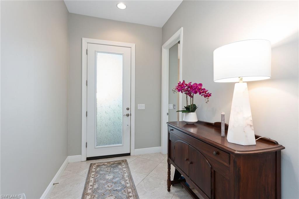 4359 Raffia Palm Circle Naples, FL 34119 - Photo 26 of 35 a room with a table and a mirror