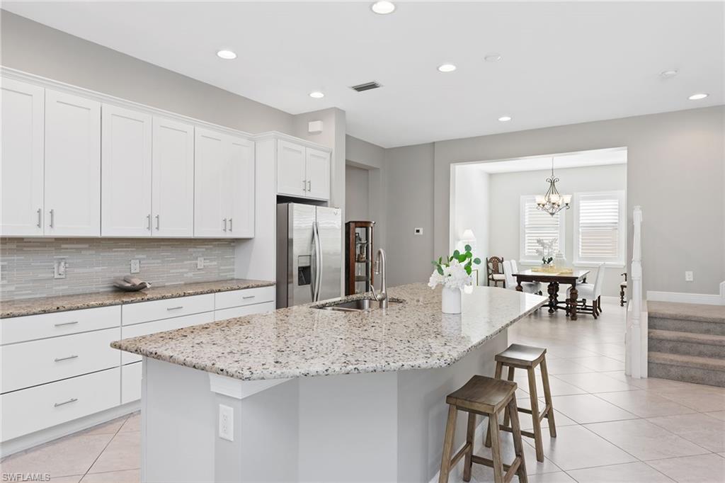 4359 Raffia Palm Circle Naples, FL 34119 - Photo 4 of 35 a kitchen with granite countertop a sink and cabinets