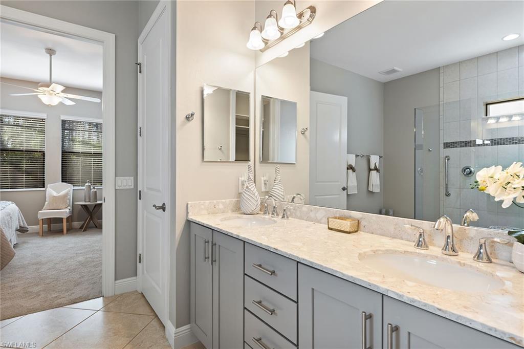 4359 Raffia Palm Circle Naples, FL 34119 - Photo 10 of 35 a en suite bathroom with double sink and a mirror