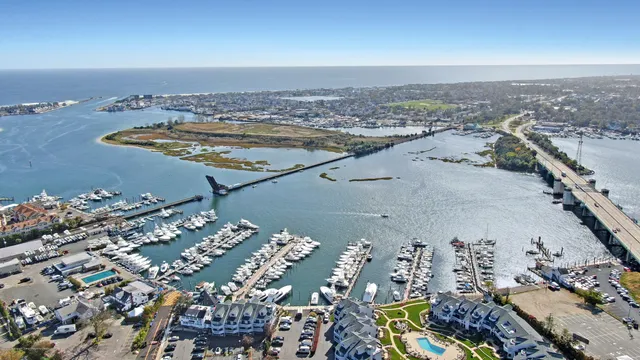 an aerial view of a city with lots of residential buildings ocean and mountain view in back