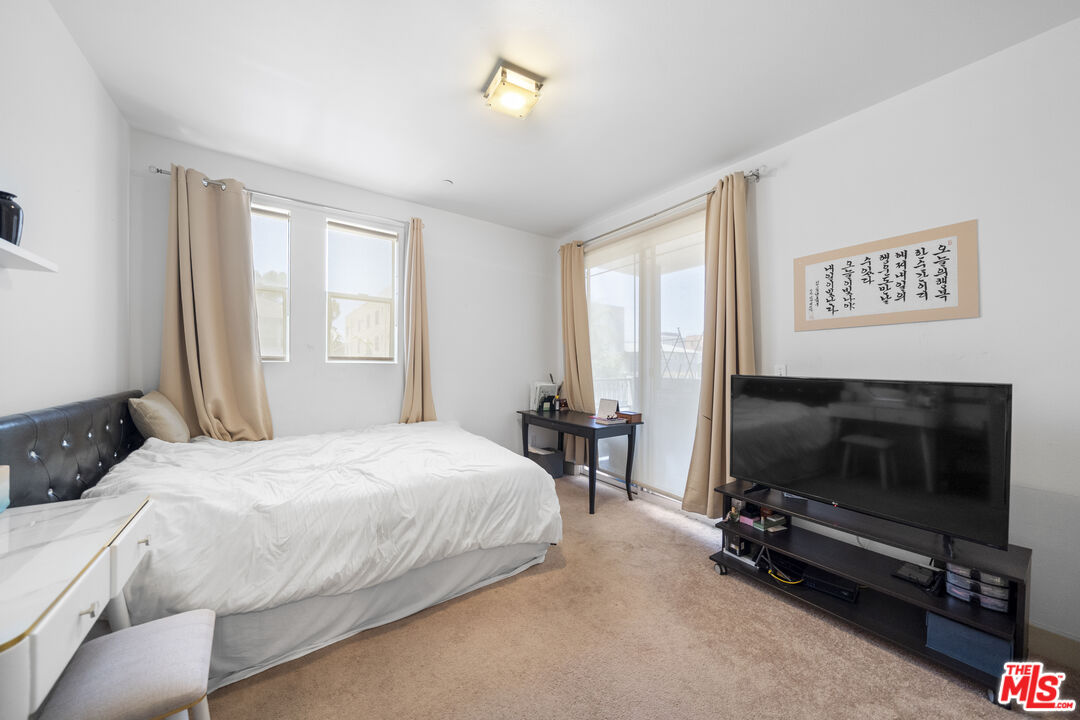 848 Irolo Street, Unit 105 Los Angeles, CA 90005 - Photo 15 of 18 a bedroom with a bed and a tv