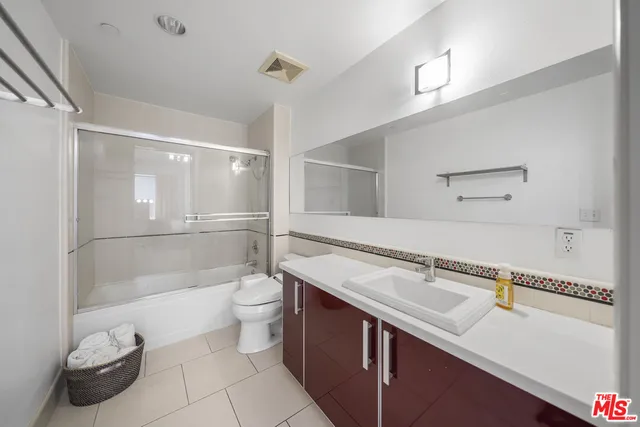 a spacious bedroom with a bed and a chandelier