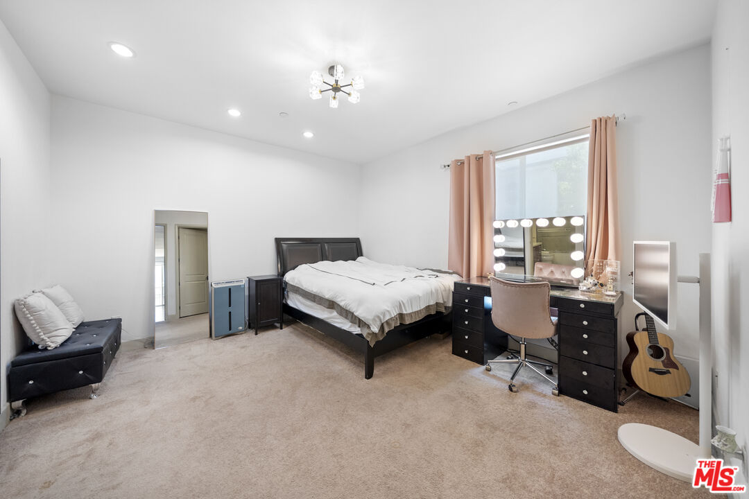848 Irolo Street, Unit 105 Los Angeles, CA 90005 - Photo 18 of 18 a spacious bedroom with a bed and a chandelier