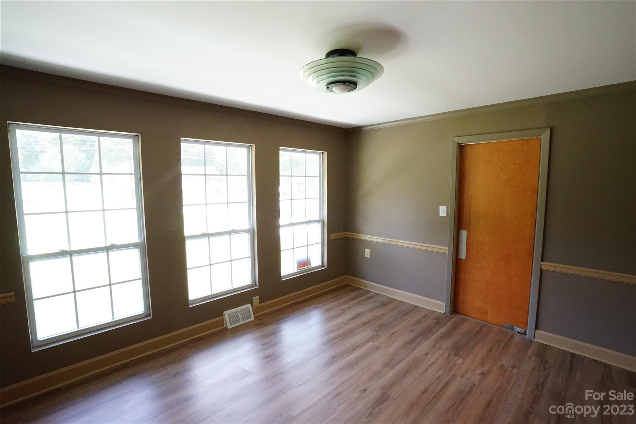 1811 Little Rock Road Charlotte, NC 28214 - Photo 11 of 20 an empty room with wooden floor and windows