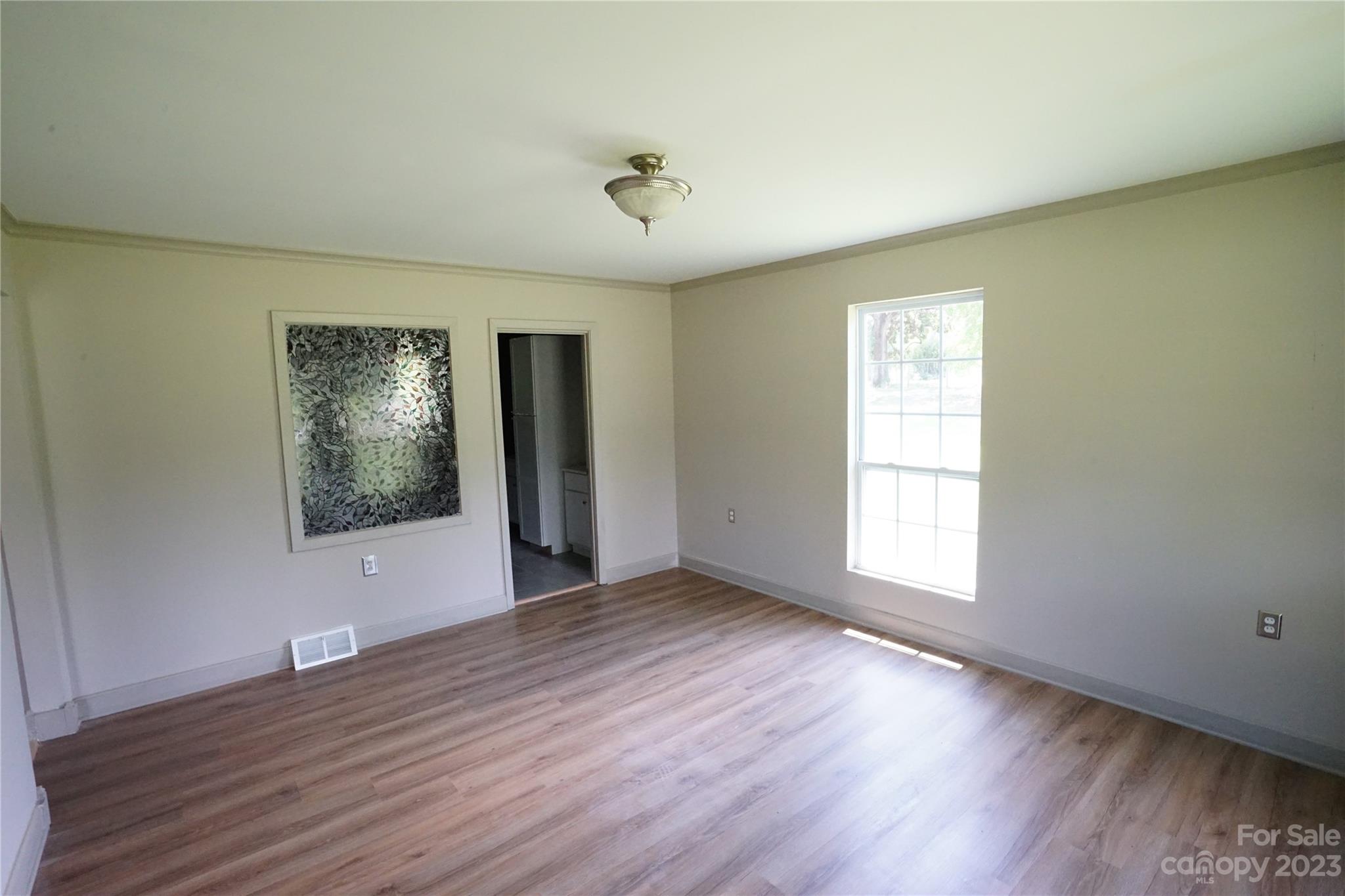 1811 Little Rock Road Charlotte, NC 28214 - Photo 16 of 20 an empty room with wooden floor and windows