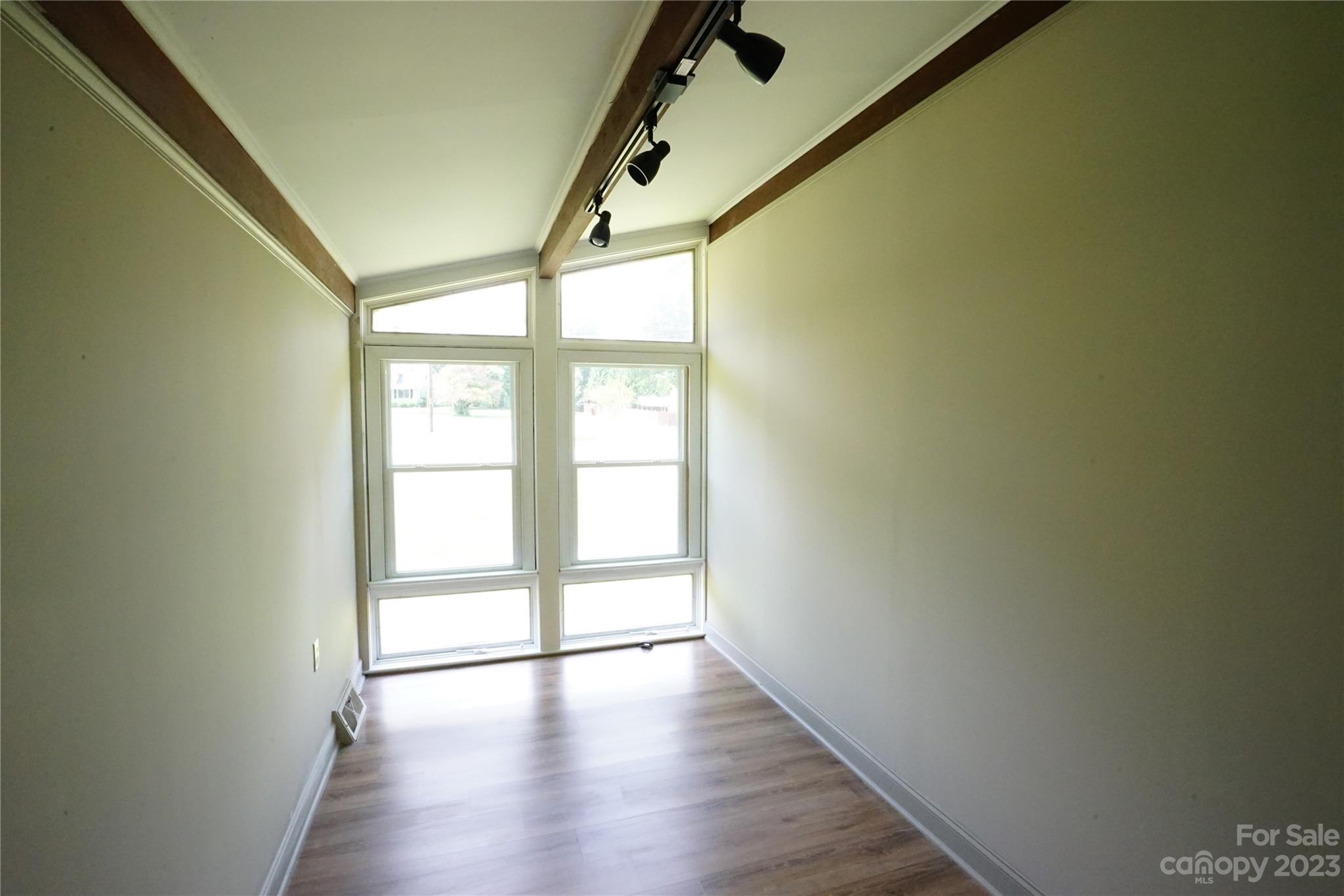 1811 Little Rock Road Charlotte, NC 28214 - Photo 17 of 20 a view of an empty room with wooden floor and a window