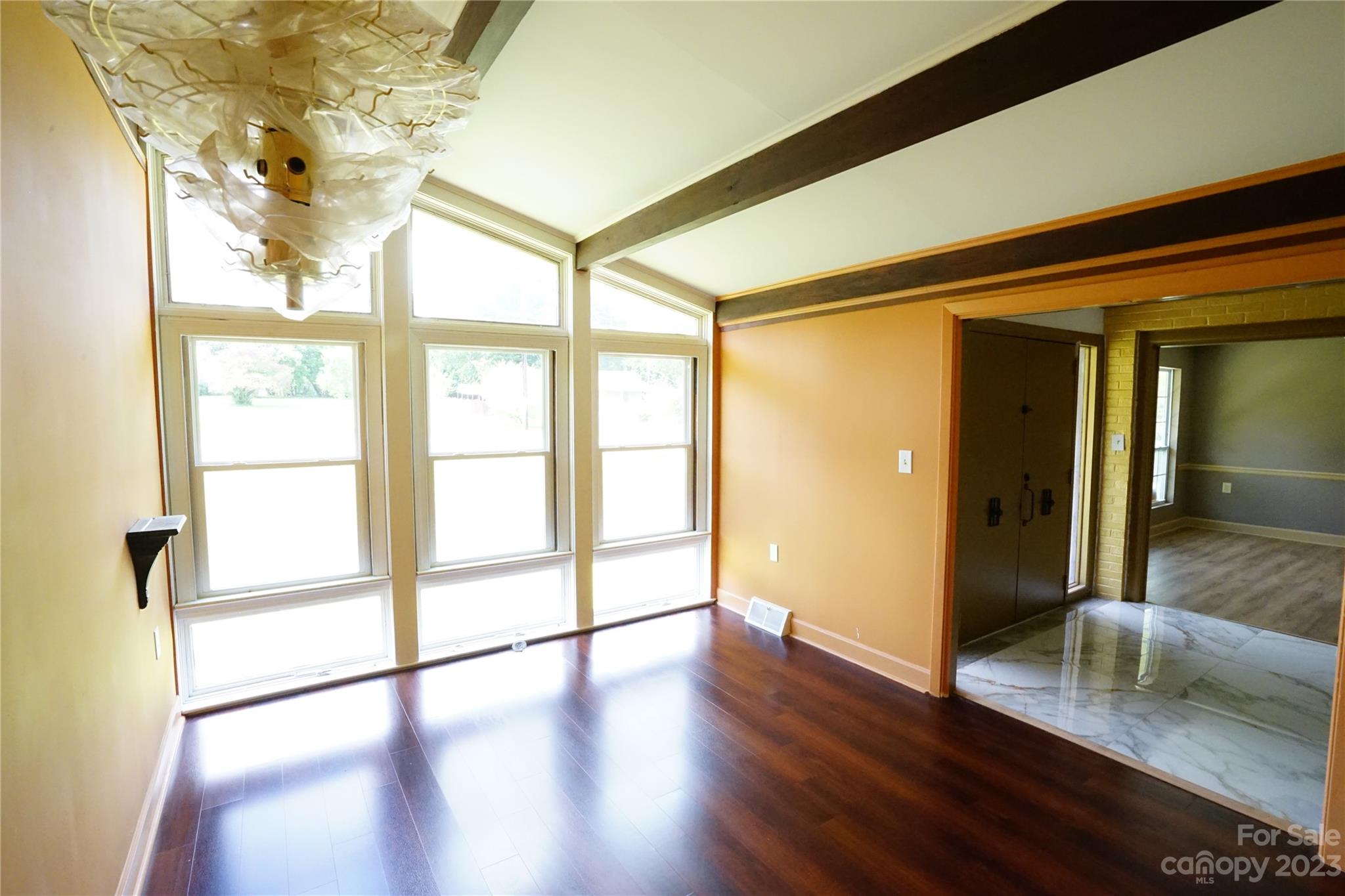 1811 Little Rock Road Charlotte, NC 28214 - Photo 9 of 20 a hallway with wooden floor chandelier and windows