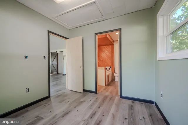 a view of hallway with a closet and wooden floor