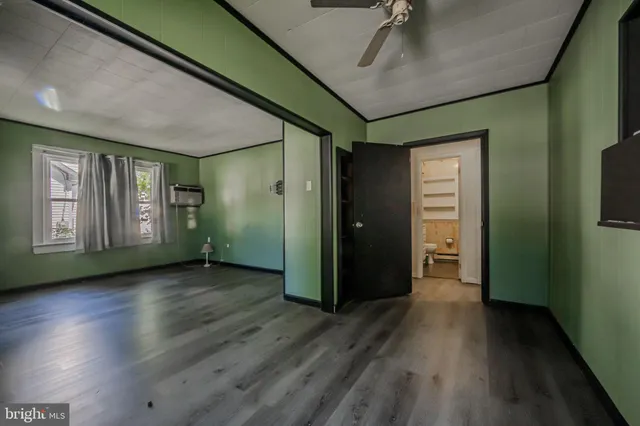 a view of an empty room with window and wooden floor