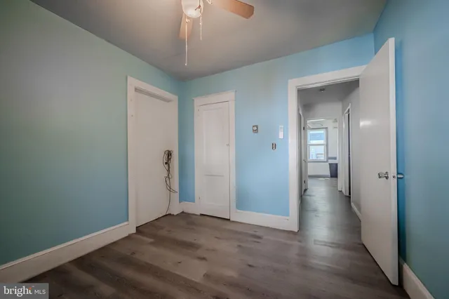 a view of a hallway with wooden floor and a chandelier