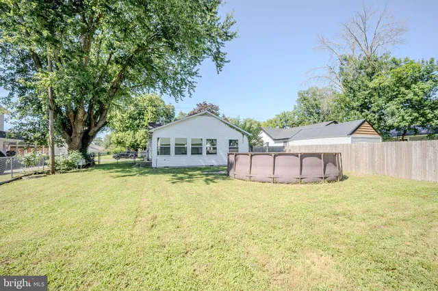 a white house with a yard and wooden fence
