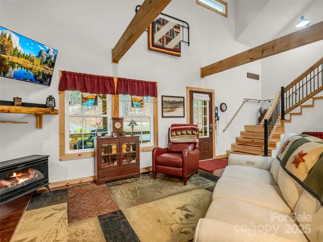 a living room with furniture a flat screen tv and a floor to ceiling window