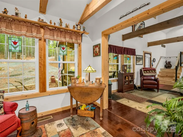 a living room with furniture a rug and a floor to ceiling window
