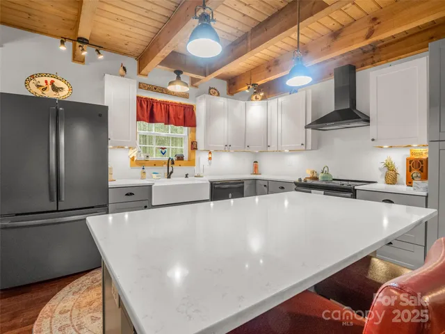 a large kitchen with stainless steel appliances a stove a refrigerator and a sink