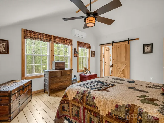 a bedroom with a bed and a dresser next to a window