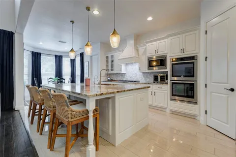 a open kitchen with stainless steel appliances granite countertop a stove and a refrigerator