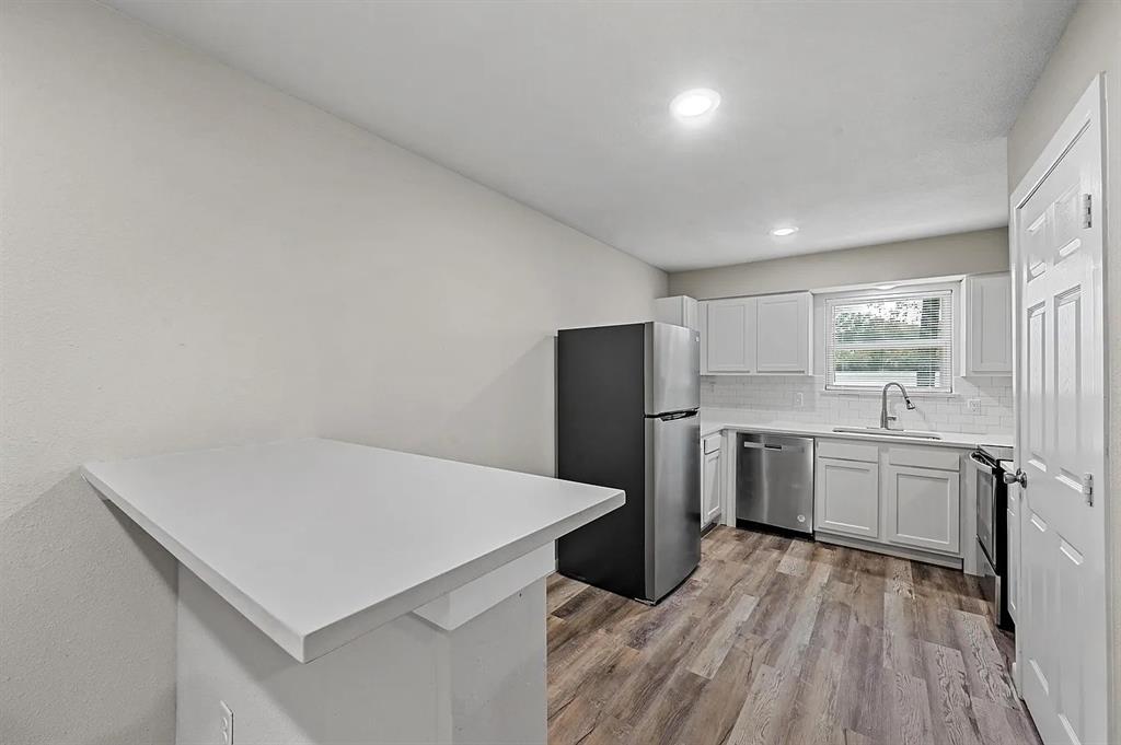 500 Highway 75, Unit 6 Van Alstyne, TX 75495 - Photo 1 of 9 a kitchen with a refrigerator a sink dishwasher with a oven and wooden cabinets