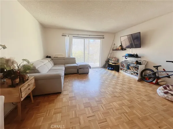 a living room with furniture a flat screen tv and a window
