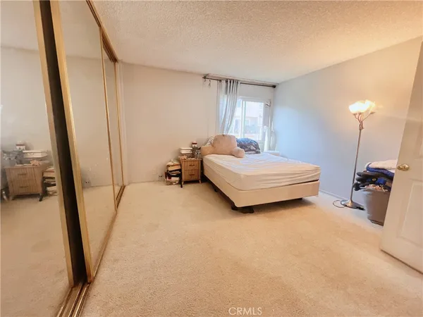 a bedroom with a bed and a large mirror