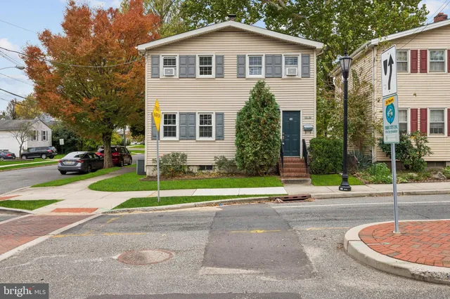 a front view of a house with a yard and trees