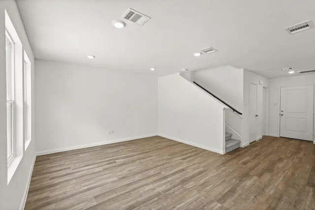 an empty room with wooden floor and entryway