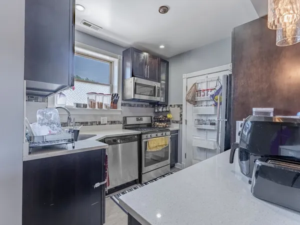 a kitchen with stainless steel appliances a sink stove refrigerator and cabinets