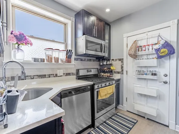 a kitchen with stainless steel appliances granite countertop a sink stove and cabinets