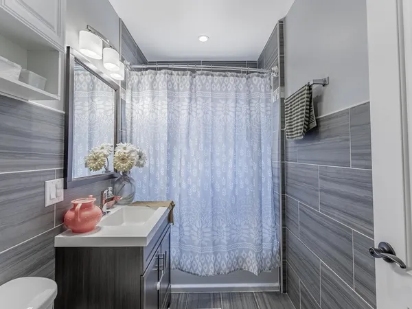 a bathroom with a sink a toilet and shower curtain