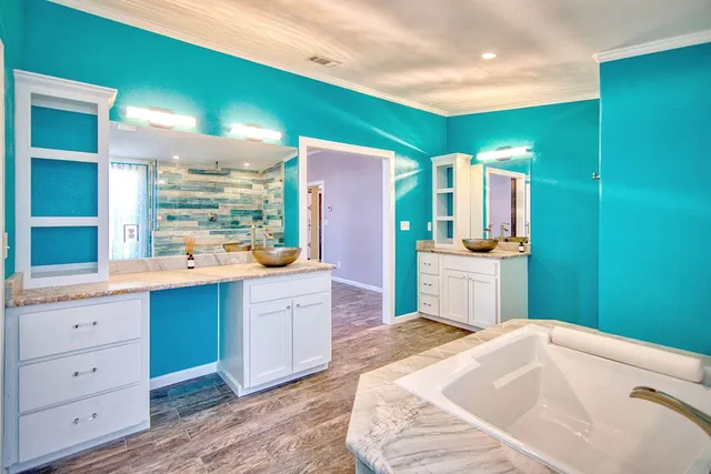 a view of an empty room with window and chandelier fan