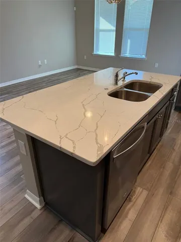 a kitchen with granite countertop a refrigerator stove and microwave