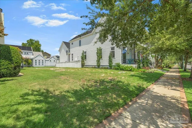 a large white house with a big yard and large trees