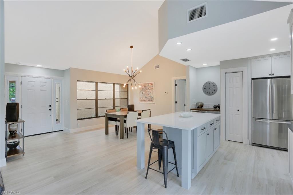 714 Reef Point Circle Naples, FL 34108 - Photo 5 of 27 a kitchen with stainless steel appliances a dining table chairs stove and refrigerator