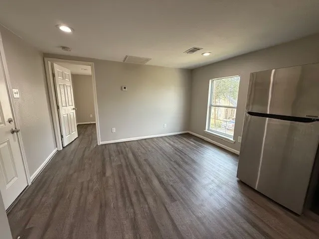 an empty room with wooden floor and a window