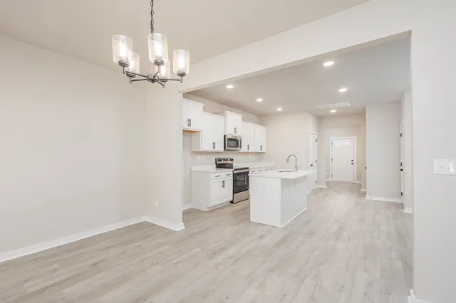 a view of a kitchen with a sink and dishwasher a refrigerator with wooden floor