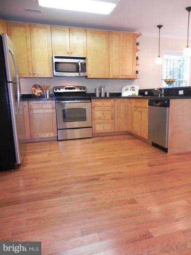 4933 Lee Street Northeast Washington, DC 20019 - Photo 5 of 21 a kitchen with stainless steel appliances granite countertop a stove a sink and a microwave