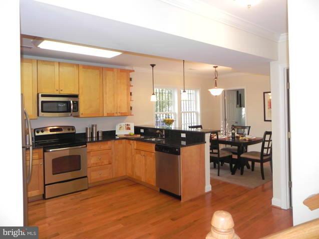 4933 Lee Street Northeast Washington, DC 20019 - Photo 9 of 21 a kitchen with stainless steel appliances granite countertop a stove top oven a sink dishwasher a dining table and chairs with wooden floor