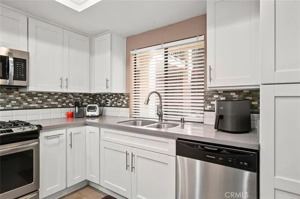 a kitchen with stainless steel appliances a sink stove and cabinets